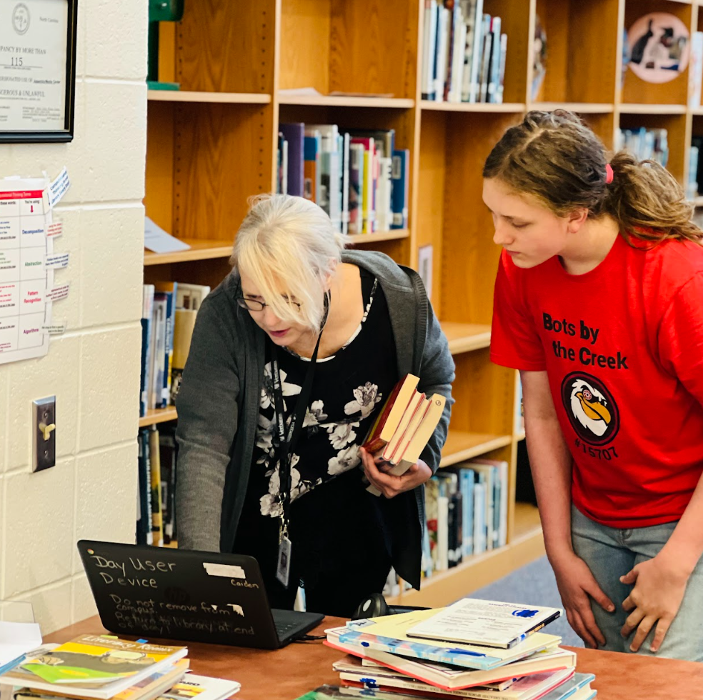 Ms. Alston, our media specialist, helps a student in the library